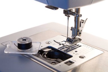 Dikiş makinesi. Kancaya yakın çekim ve ayaklar dikiş makinesinde.