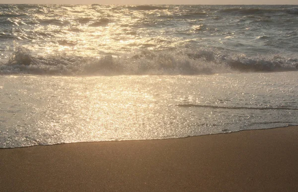 Sea waves and sand. Sunset and evening sun. Summer