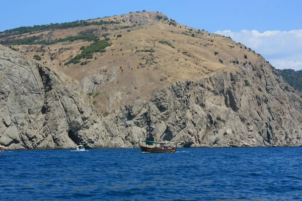 Büyük Bir Kayanın Arka Planı Mavi Denizde Bir Tekne Yaz — Stok fotoğraf