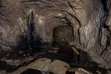 Yeraltı terk edilmiş demir cevheri tüneli ve siyah su.