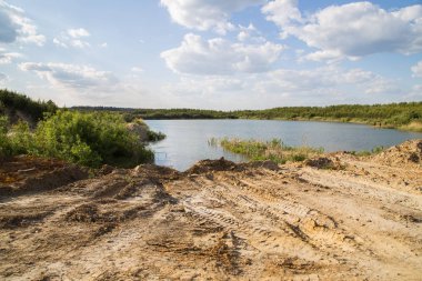 Açık kaolin kil ocağını mavi su gölüyle doldurmuş.