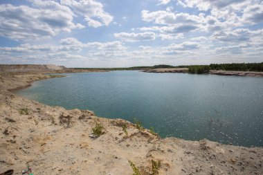 Açık kaolin kil ocağını mavi su gölüyle doldurmuş.