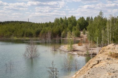 Açık kaolin kil ocağını mavi su gölüyle doldurmuş.