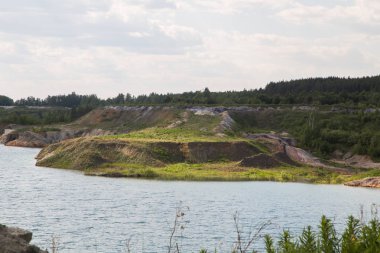 Açık kaolin kil ocağını mavi su gölüyle doldurmuş.