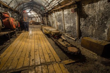 Yeraltı kömür madeni tüneli raylar ve ışık ile sürükleniyor