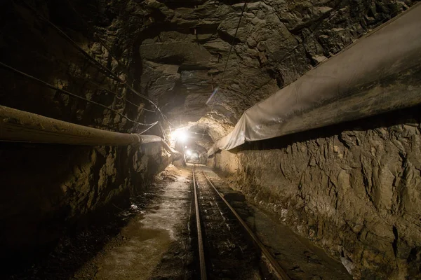 Gold ore mine tunnel with rails