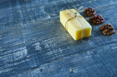 Sarı peynir, mavi ahşap bir masada ceviz kabuğu.