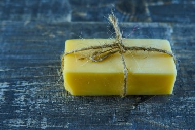 Mavi ahşap masada ipli sarı sert peynir.