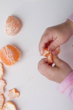 kız \'s el mandalina beyaz arka plan üst görünüm turuncu pembe bir dilim tutun