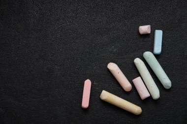 siyah bir arka plan üzerinde renkli boya kalemleri, kopya alanı, üst görünüm