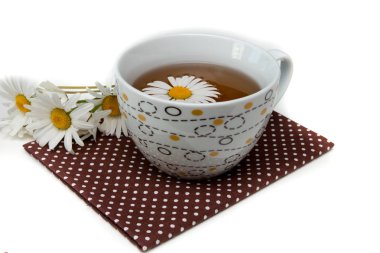 papatya çayı ile bir desen ile beyaz fincan, beyaz bir arka plan izolasyon üzerinde kahverengi bir polka nokta kumaş papatya çiçekleri