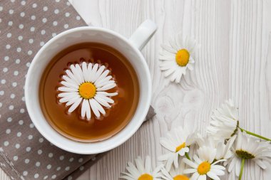 beyaz bir arka plan üst görünüm kopya alanı üzerinde kahverengi bir polka nokta kumaş üzerinde çay papatya fincan