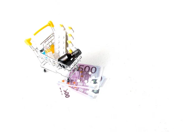 药品采购概念 注射器和药瓶在购物车和500欧元的账单在一个白色背景复制空间 — 图库照片