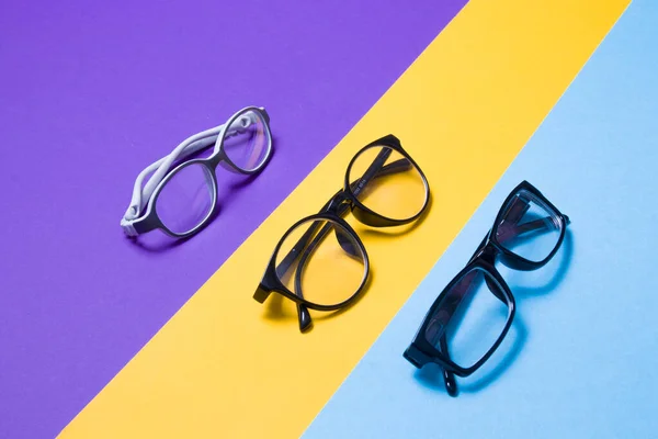 彩色背景的成人和儿童的几副眼镜 黄色和紫色背景的 复制空间的 眼镜商店概念 镜头商店 — 图库照片