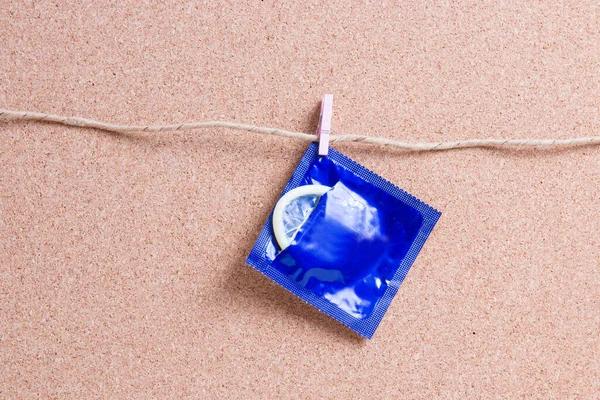 Otevřený Obal Kondom Visí Malém Dřevěném Kolíku Papírové Niti Pozadí — Stock fotografie