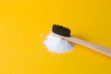 Sarı arka planda bir yığın soda üzerine bambu diş fırçası. Kopya diş fırçası, gazoz konsepti, sıfır atık yaşam tarzı konsepti.