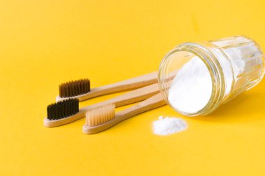 Sarı zemin üzerinde soda bulunan bambu fırçaları ve cam kavanozlar, fotokopi alanı, çevre dostu yaşam tarzı kavramı