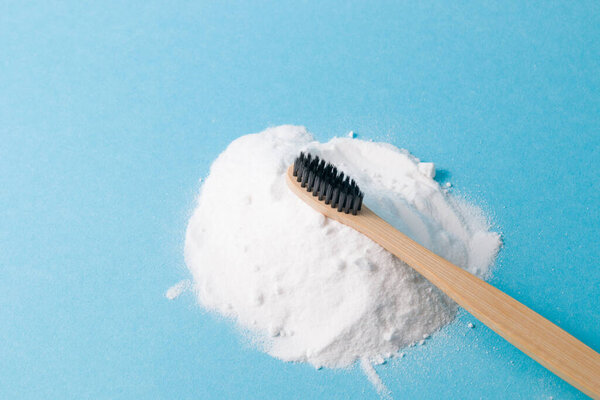 bamboo toothbrush on pile of soda on blue background place copy brushing teeth soda concept, zero waste lifestyle concept