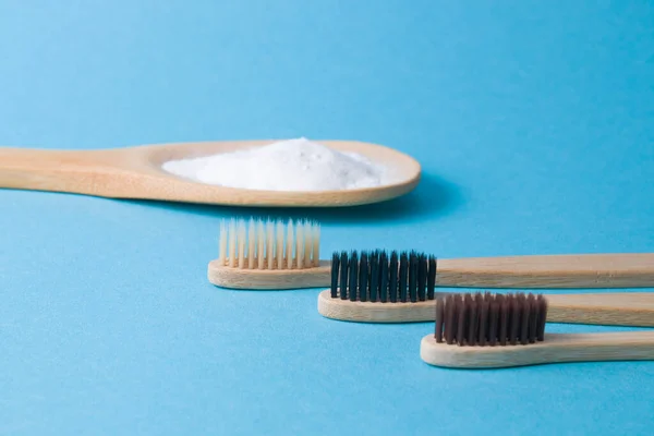 Tres Cepillos Bambú Diferentes Una Cuchara Madera Con Soda Sobre — Foto de Stock