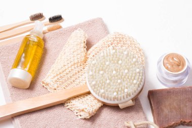 Çevre dostu hijyen seti, bambu diş fırçaları, beyaz arka planda ev sabunu, kuru masaj için ahşap fırça ve beyaz arka planda duşta masaj yapan eller.