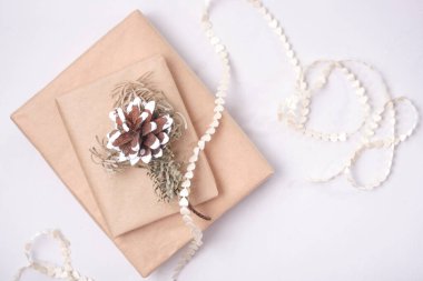 Küçük kalp kurdelesi ve kurumuş köknar dalı ve çam kozalağı hediye kutusuna sarılı gri arka plan manzaralı bir yerde fotokopi çekilecek çevre dostu yaşam tarzı için