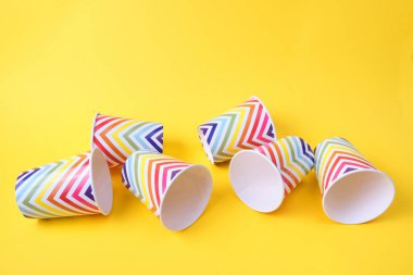 Sarı arka planda geometrik desenli düşmüş kağıt tatil bardakları