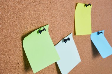 Mantar panoya tutturulmuş birkaç renkli not kağıdı, seçici odak, kopyalama alanı