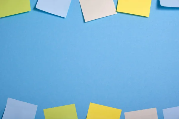 bright colored sticky notes on a blue background in two rows