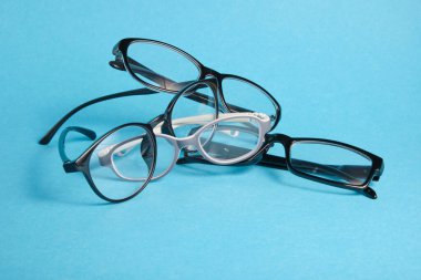 Mavi arka planda çeşitli bardaklar, çocuklar ve yetişkinler için gözlük, fotokopi yeri