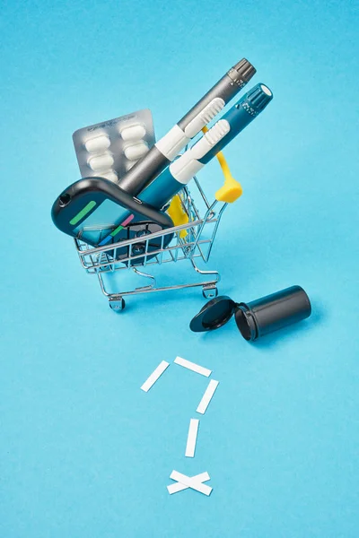 Diabetes concept. Diabetic supplies in shop trolley on a blue background.