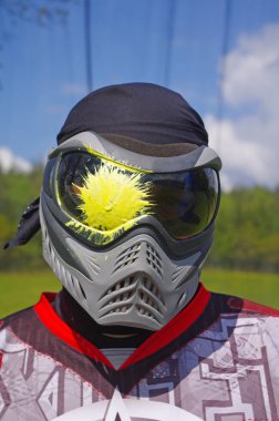 Paintballer portre. Paintball spor oyuncu ile sıçramak maskesini üzerinde sarı boya. Paintballer portre