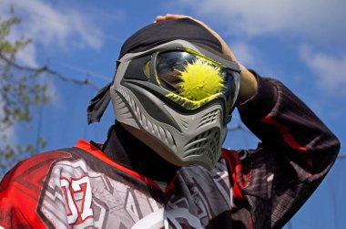 Paintball spor oyuncu ile sıçramak maskesini üzerinde sarı boya. Paintballer portre