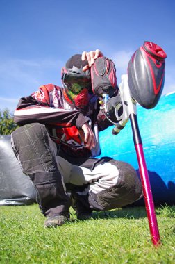 Paintball spor oyuncu ile sıçramak maskesini üzerinde fluo yeşil boya. Yenilgi sonra depresif paintballer.