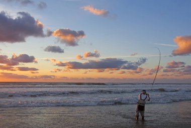 Surf balıkçılık sahne, sörf balıkçı dalgaların içine. Deniz balıkçılığı, bir balık yakalamak. Gece balık