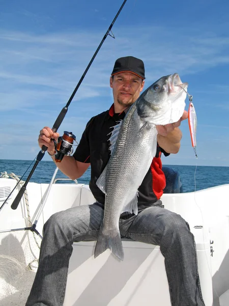 幸运的渔夫拿着一个大的海低音 海上捕鱼 咸水捕鱼 — 图库照片