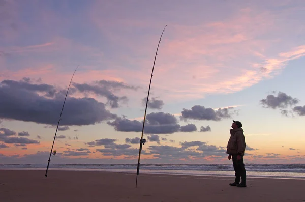 ビーチからの海釣り 日没時に魚を待っているサーフィン漁師 — ストック写真