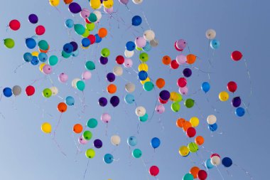 Renkli balonlar uzakta masmavi gökyüzünde uçan bir sürü