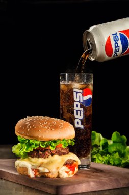 Açıklayıcı makale lezzetli burger ve dökme bir cama Pepsi. Öğle yemeği için en popüler lokanta kombinasyonu.