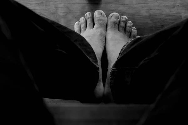 Bare feet on wood floor background Top view