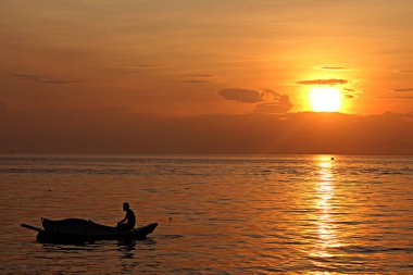 Sabah Beach gündoğumu tekne siluet adama ile