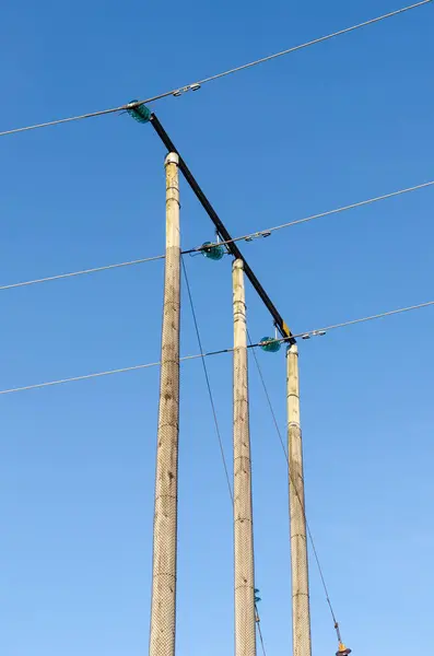 Przewody przesyłu energii elektrycznej przez słupki drewniane — Zdjęcie stockowe