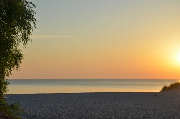 Sunset by a beautiful empty sand beach — Stock Photo, Image