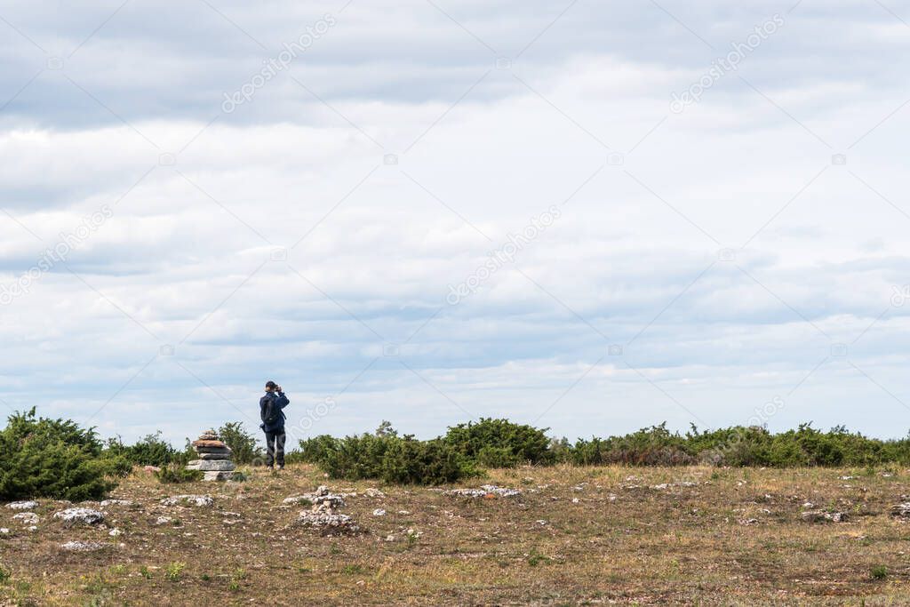 Visitor in the wide barren grassland in the World Heritage of Southern Oland in Sweden