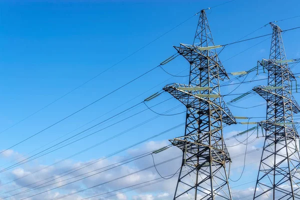 Mavi gökyüzü arka plan üzerinde elektrik telleri ile yüksek gerilim iletim hattının iki destekler.