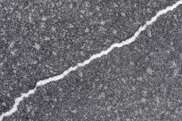 うっすらと雪化粧し 斜め上方の灰色の氷の上亀裂 — ストック写真