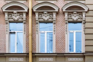 Üç dikdörtgen pencere eşiği ile bir kemer ve pembe tuğla bir duvar arka plan üzerinde bir kısma. Saint-Petersburg windows serisinden.