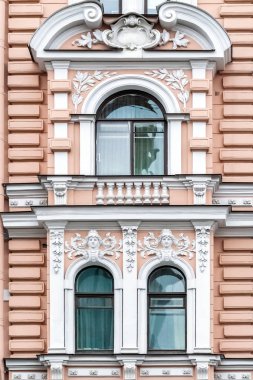 Üç kemerli pencereler pembe duvar arka plan üzerinde beyaz sıva ile. Windows St Petersburg bir dizi.