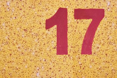 Sarı bir duvara 17 numara kırmızı boya sıçramış..