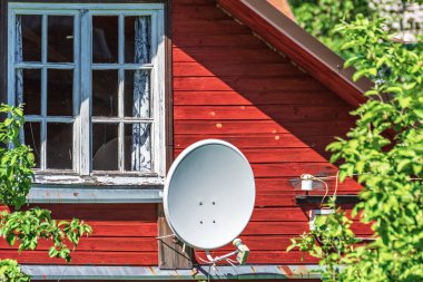 Kırmızı kır evindeki uydu anteni.