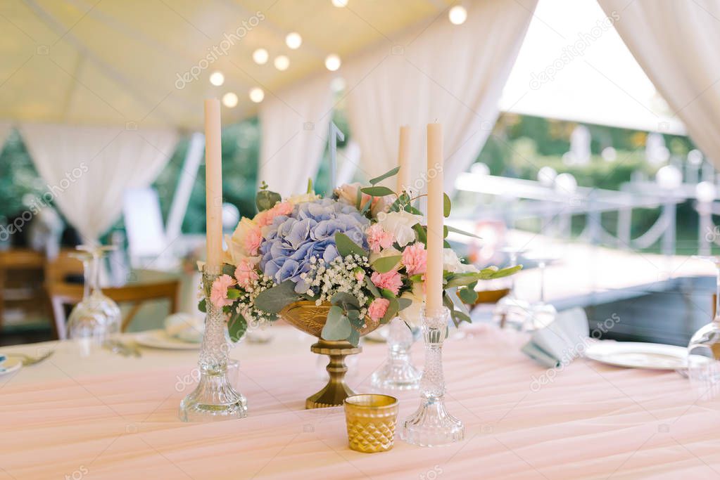 Beautiful wedding decor on round tables in gentle flowers